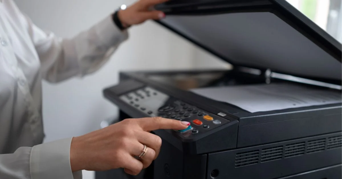 Close-up of hand pressing button on office printer